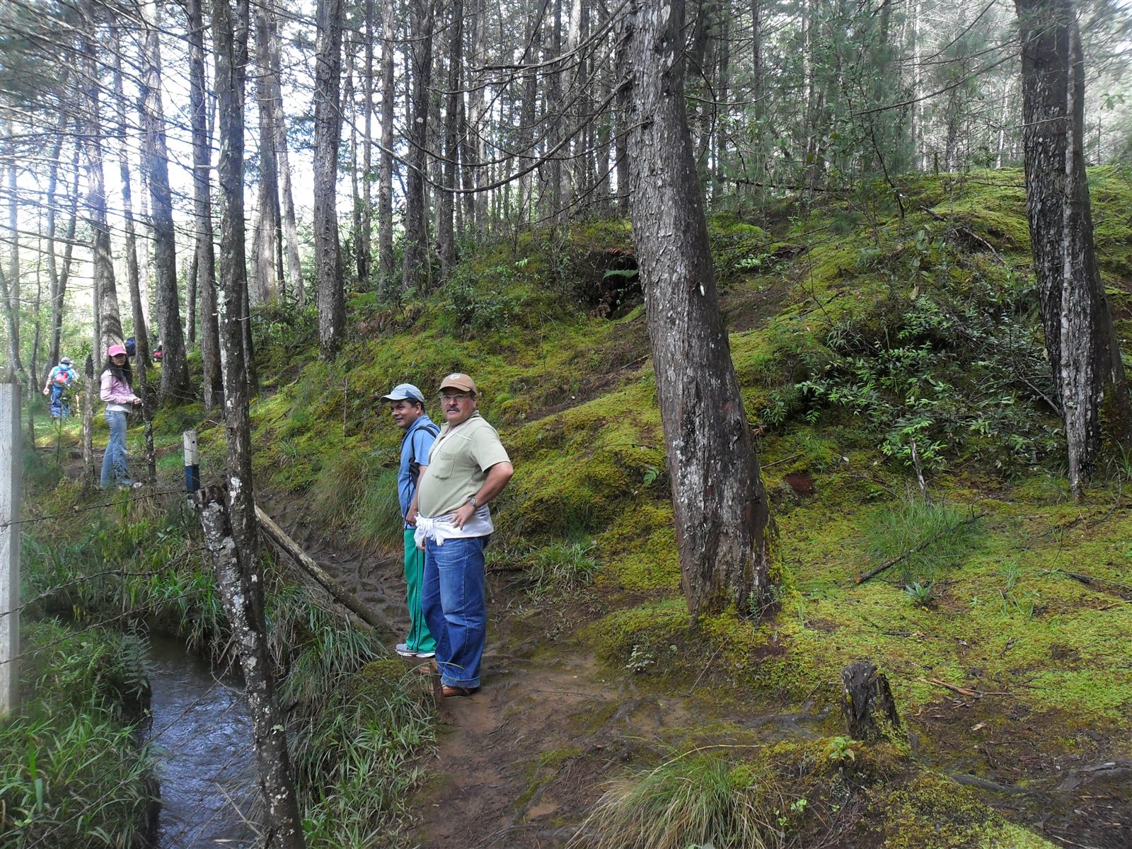 Integrantes de la comunidad junto a una corriente de agua en el bosque